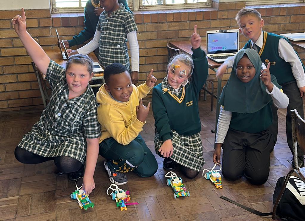 Excited learners celebrating with their LEGO robots they built and coded