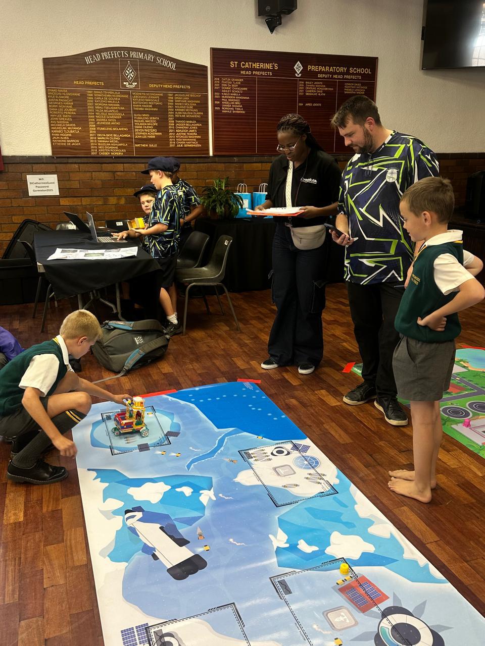 Robotics competition event with learners programming robots on a challenge mat